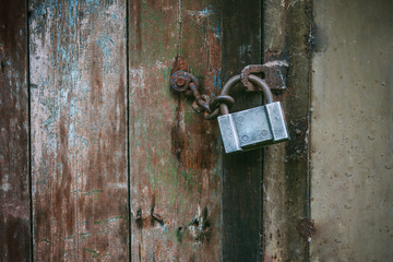old lock and chain around wooden fence