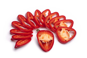 Red pepper is cut in rings, a piece of pepper is like a smile, looks like a mouth with teeth, laughing on a white background top view isolated