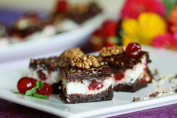 Milk mousse cake decorated with cherry and walnuts