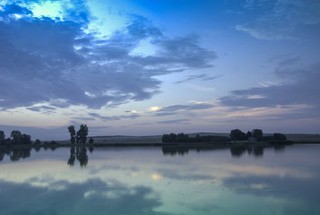 Fototapeta na wymiar Blue evening clouds on the lake