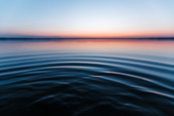 Obraz premium ircles on the water against a beautiful, pink sunset. The magic time of day.