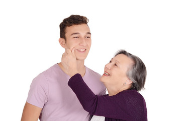 Grandmother kissing her teen grandson on the cheek