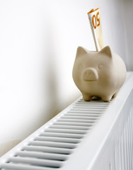 Radiator, piggy bank and fifty euro. Piggy bank on heating battery.