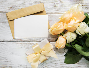 White roses and greeting card on a old wooden table
