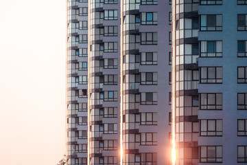 Fototapeta premium Building facade background. Exterior and rhythm of several identical residential buildings in row on modern city street.