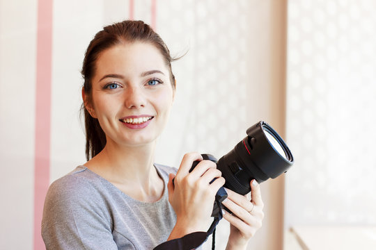 Portrait of Girl photographer smiling and holding her camera