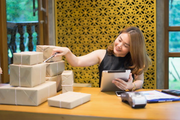 Shipping shopping online ,young start up small business owner writing address on cardboard box at workplace. seller prepare parcel boxs of product for deliver to customer.Online selling or e-commerce