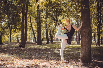 Ballet dancer dancing in the city park. Sensual ballerina in nature. Ballerina on the streets. Ballerina out of doors, young modern ballet dancer posing 