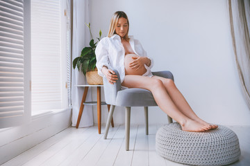 Fototapeta na wymiar Pregnant mothercare lifestyle concept, blond Bob hairstyle woman health care. white light interior
