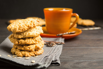 Vertical stack of five cookies of oat with brown cup with copy space