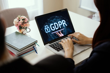 GDPR Concept,A girl works at laptop and hand holding digital tablets sign general data protection...