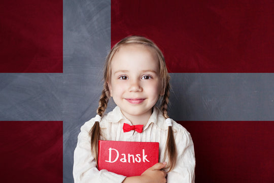 Danish concept. Child girl student with book against the Danish flag background. Learn language