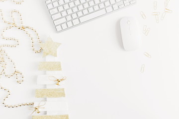 Christmas home office desk with computer, christmas tree, gift, golden decorations. Flat lay, top view, copy space 