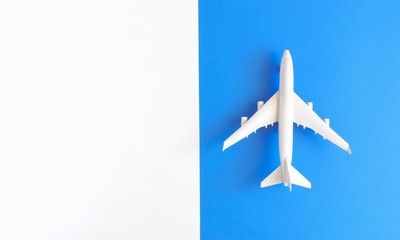Airplane model. White plane on white and blue background. 