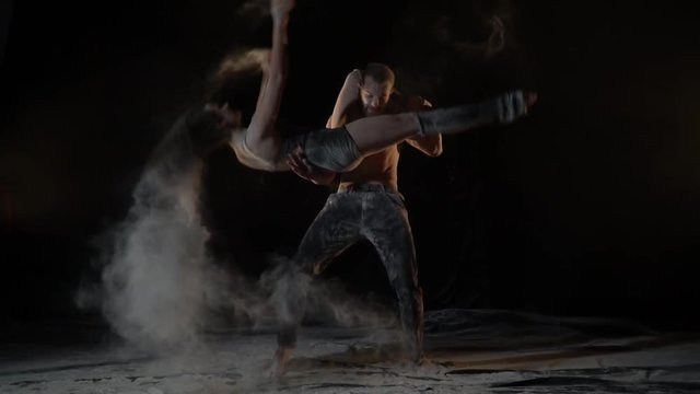 Slow motion shooting, a beautiful pair of acrobats in flour