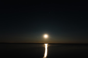 Night moon sky, full moon, Moon over the lake. Night landscape. Reflection of the rays from the moon in the water.
