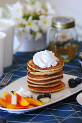 Breakfast pancakes served with honey and fruits