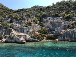 Kayakoy Kekova(Simena) village,Fethiye,Mugla Sunken city of Kekova in bay of Ucagiz view from sea in Antalya province of Turkey with turqouise sea rocks and green bushes with remains of ancient city