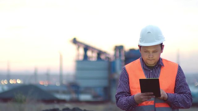 Oil refinery plant at sunrise with sky background,silhouette and Power plant,blur,bokeh. Engineer in a helmet on the background of an industrial plant