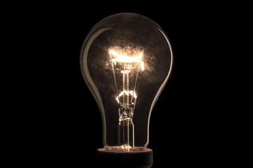 Realistic electric light bulb on black background.