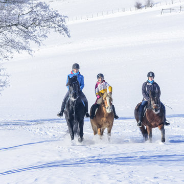 gutgelaunte Reiterinnen im Schnee