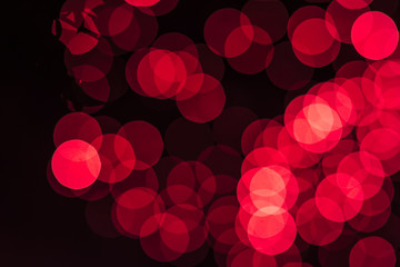 Abstract defocused red glittering shine bulbs lighting bokeh on blurred green background in colorful warm tone for Christmas and New Year conceptsparkling golden