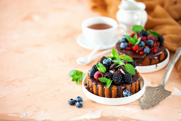 Cake in chocolate glaze with berries. Selective focus. Sweet summer dessert.