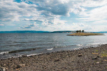 scenic view of Mjosa lake with small island and cloudy sky, Hamar, Hedmark, Norway