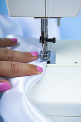 Woman sews on a sewing machine.