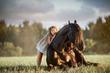Little  girl with black friesian stallion  - 224493987