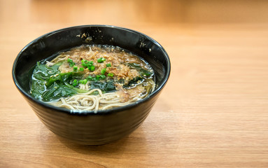 Soba herb noodles in hot soup, take up by chopsticks from bowl. traditional japan food. noodles from grains. image for background, wallpaper, copy space. cultural asian cuisine