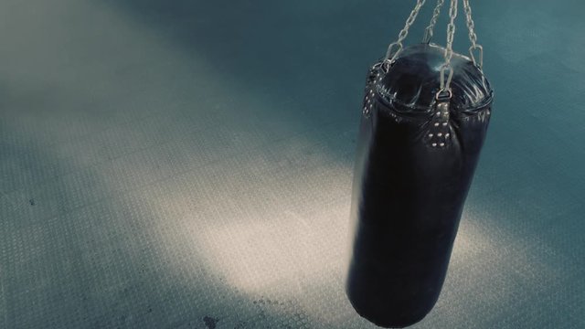 punching bag hanging in kickboxing fitness gym swinging motion top view