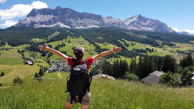 Successful woman raising hands in the mountains, Dolomites, Italy