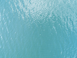 Fototapeta na wymiar Aerial view of a Crystal clear sea water texture. View from above Natural blue background. Turquoise ripple water reflection in tropical beach. Blue ocean wave. Summer sea. Drone. Top view