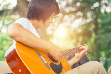 Fototapeta premium The guy playing the guitar, outdoor, cargo pants