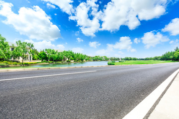 Asphalt road and woods with apartment buildings in the city suburbs