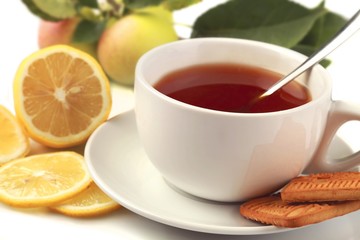 Hot drink with a lemon, cookies and apples