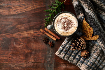 Cup of cappuccino coffee with spices for a cold autumn day. Flat lay. Wooden background. Copy space