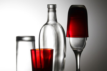 A transparent bottle and red glasses