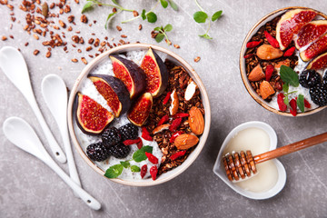 Granola with figs,yogurt,nuts,berries,Goji berries and honey and a Cup of coffee with milk. Healthy Breakfast.  top view.selective focus.