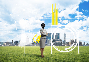 Camera headed woman standing on green grass against modern cityscape
