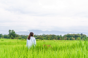 Fototapeta na wymiar An umbrella woman wearing a green shirt in a field