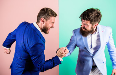 Business competition and confrontation. Hostile or argumentative situation between opposing colleagues. Business partners competitors office colleagues tense faces ready to compete in arm wrestling