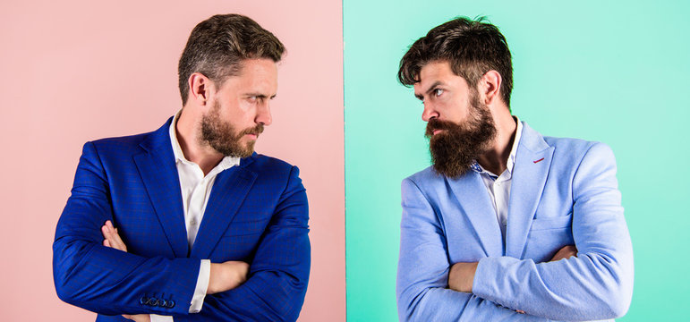 Business partners competitors in suits with tense bearded faces. Businessmen stylish appearance jacket pink blue background. Tense face expression competitors. Business competition and confrontation