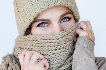 Close-up portrait of a woman in a scarf and hat with beautiful blue eyes