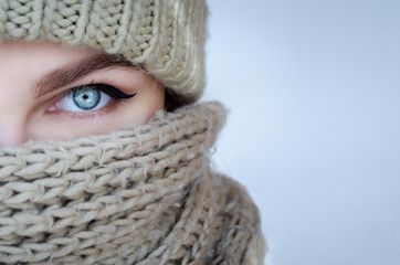 Close-up portrait of a woman in a scarf and hat with beautiful blue eyes
