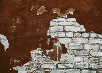 Empty old brick wall texture. Plastered wall. Old stucco. Old damaged brick wall with brown plaster. Exposed plaster. Shabby building facade with damaged plaster