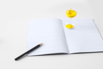 pen, notebook, sand watch 