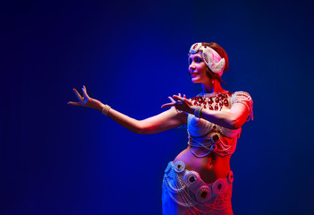 Beautiful oriental dancer in a white pearl costume
