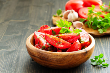 Appetizer of salted tomato with garlic and herbs.